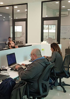 Photo of people working with laptops in an office