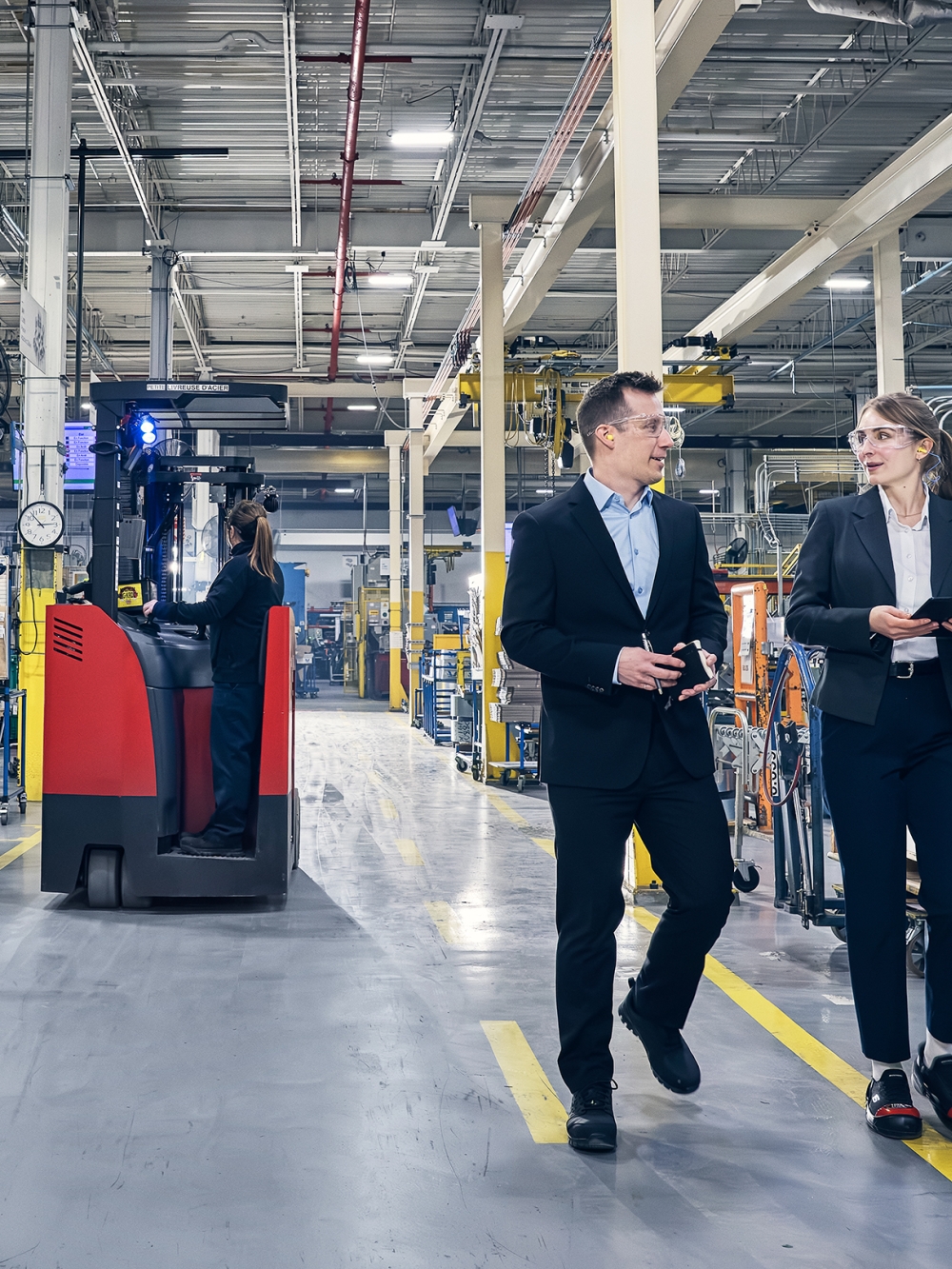 Une conseillère et un PDG sur le plancher d'une usine
