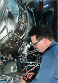 Photo of a technician repairing an aircraft engine