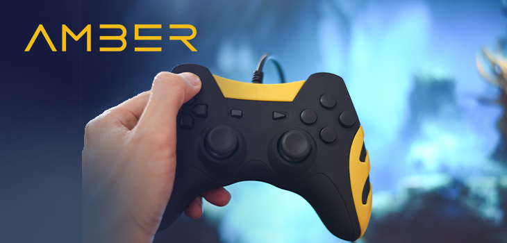 Image d’une main tenant une manette de jeu vidéo accompagnée du logo d’Amber