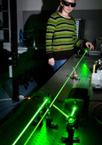 Photo d’une technicienne faisant des essais d’optique-photonique dans un laboratoire