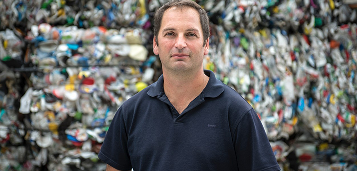 Photo de Martin Ménard, président d’Absolu technologies de recyclage, devant des matières recyclables