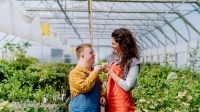 Une personne trisomique et une employée travaillent ensemble dans une serre