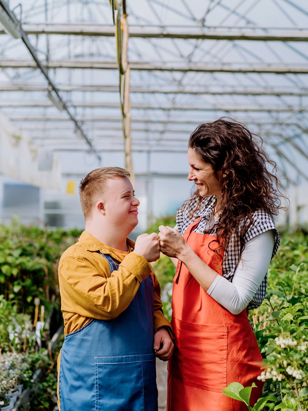 Une personne trisomique et une employée travaillent ensemble dans une serre
