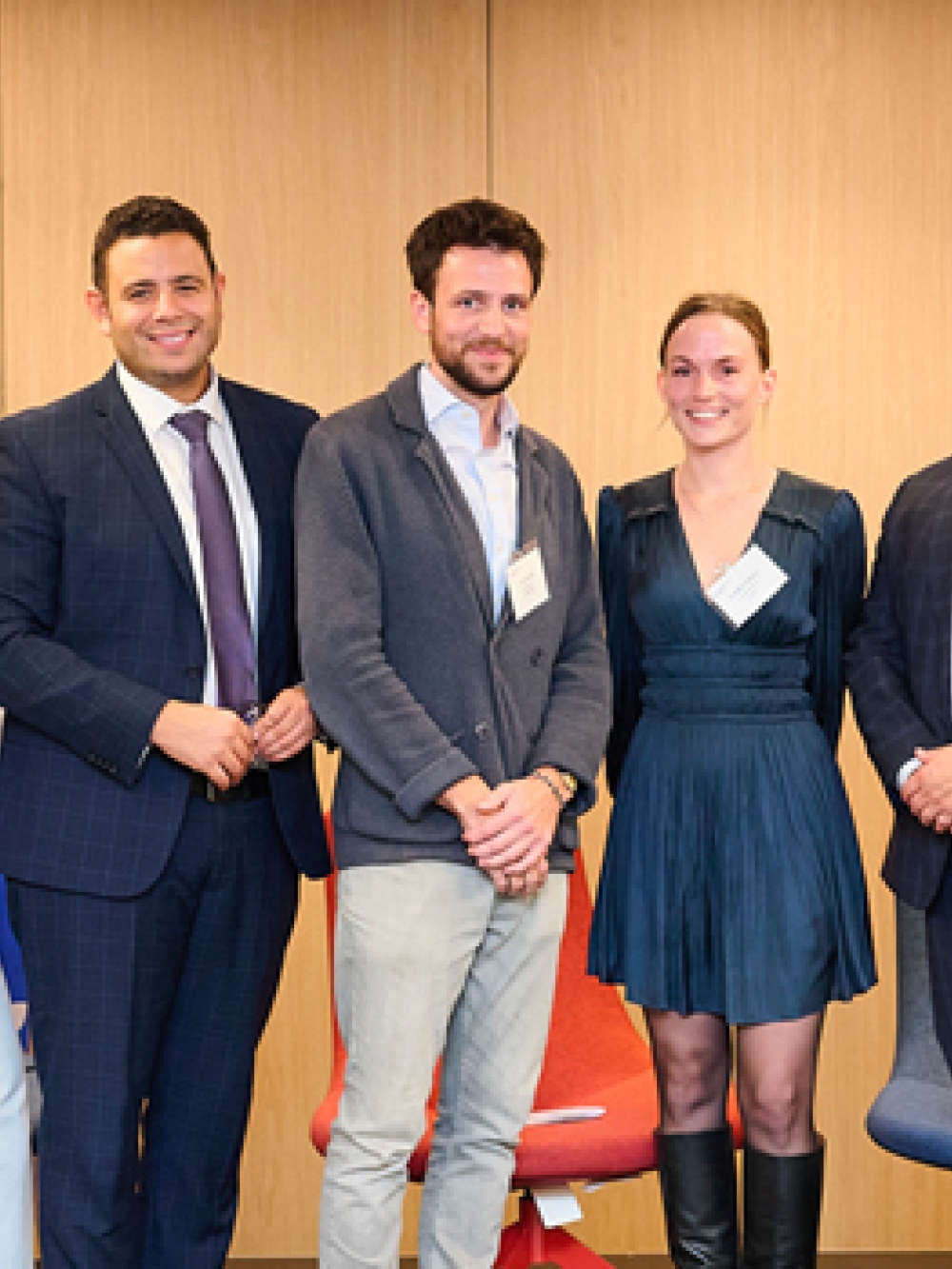 Groupe de personnes debout dans une salle de conférence, posant devant deux bannières d’Investissement Québec et un drapeau du Québec.