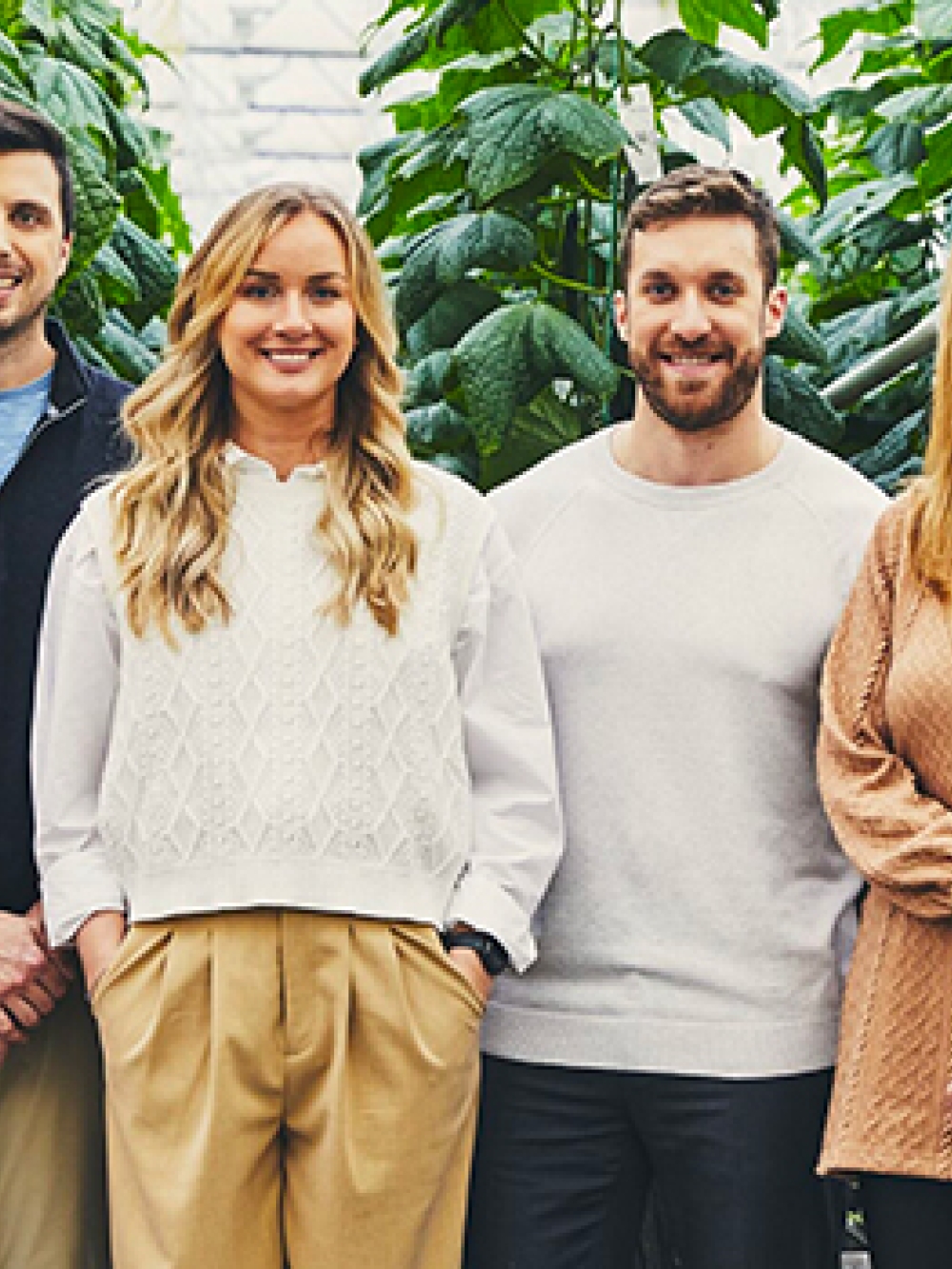 Groupe de personnes posant dans une serre parmi des plants en croissance, représentant l’équipe de Cultures Gen V.