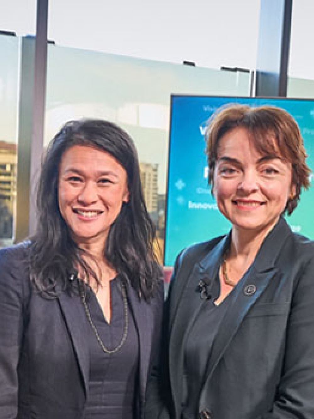 Groupe de personnes en tenue professionnelle posant devant des écrans.