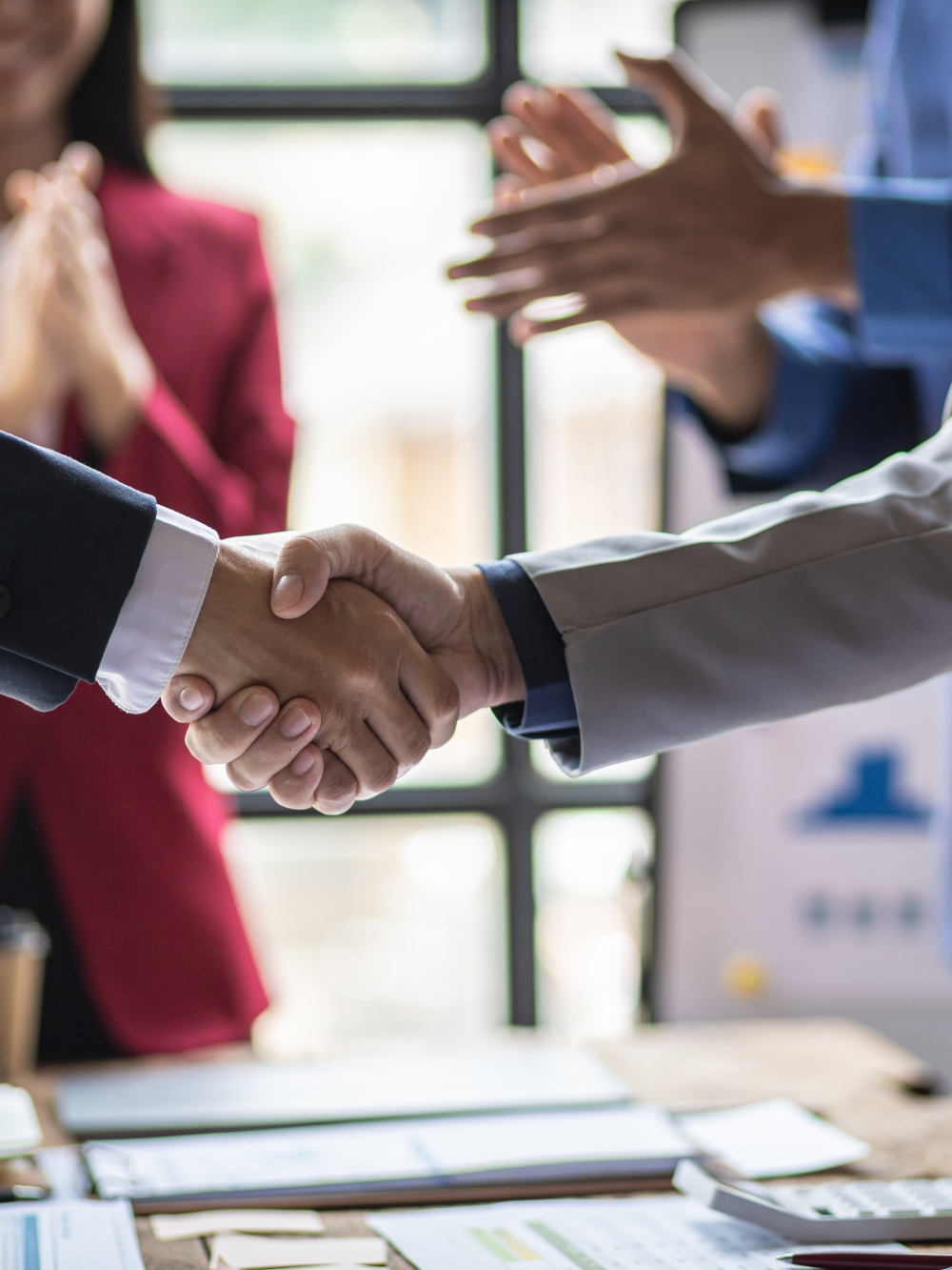 Deux hommes se serrant la main au dessus d'une table