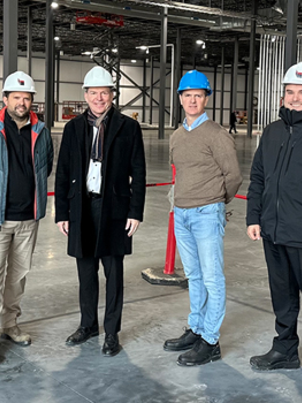 Groupe de personnes tenant un ruban bleu portant le nom « Duravit » lors d’une cérémonie d’inauguration à l’intérieur d’une usine.