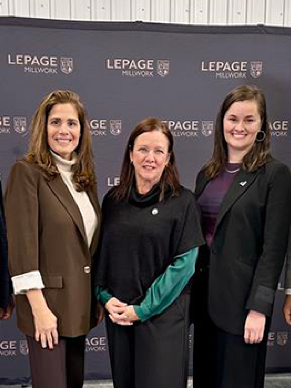 Groupe de personnes posant devant un mur promotionnel de Lepage Millwork et une bannière d’Investissement Québec lors d’un événement officiel.