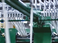 Machine textile en fonctionnement, montrant des fils en cours de transformation dans les équipements de production de FilSpec.