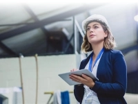 Une ingénieure prend des notes dans une usine