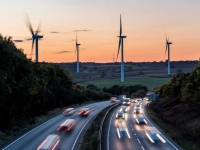Voitures circulant sur une autoroute avec des éoliennes en arrière-plan