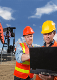 Photo de deux ingénieurs qui consultent un portable sur un chantier
