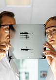 Photo of two biologists looking at an X-ray of DNA